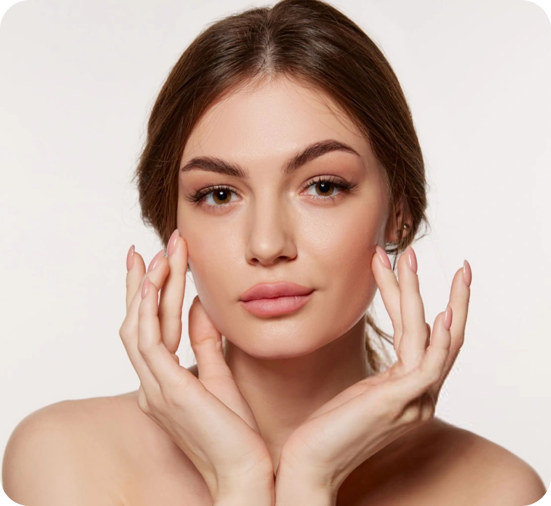 Woman with hands near face demonstrating skincare treatment results